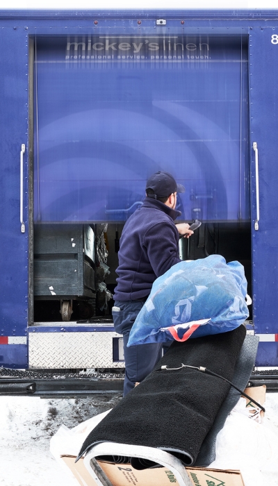 Mickey's Linen Truck Loading employee loading linens (1) Mickeys-Linen-Truck-Loading-employee-loading-linens