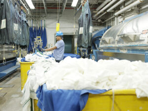 Employee on the wash aisle where hygienically clean food service linen and uniforms are cleaned.